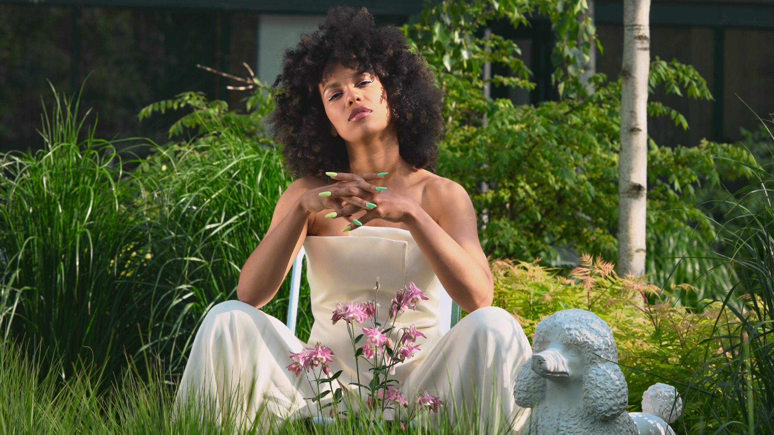 Kobieta w ogrodzie, wśród kolorowych kwiatów, relaksuje się w pięknym otoczeniu.