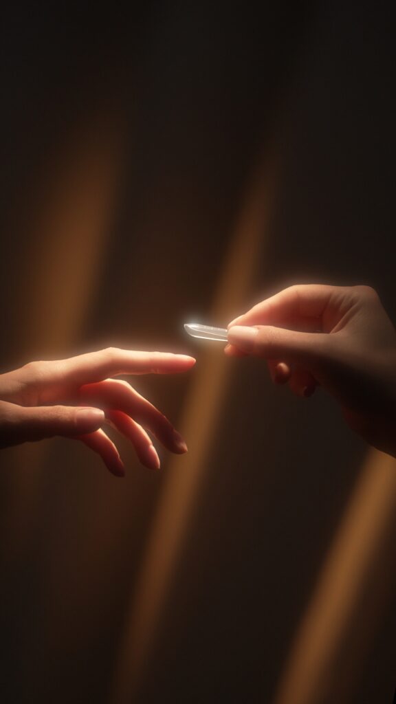 Dwie dłonie, jedna podająca tips Indigo Nails, sięgają ku światłu, nawiązując do "Stworzenia Adama".