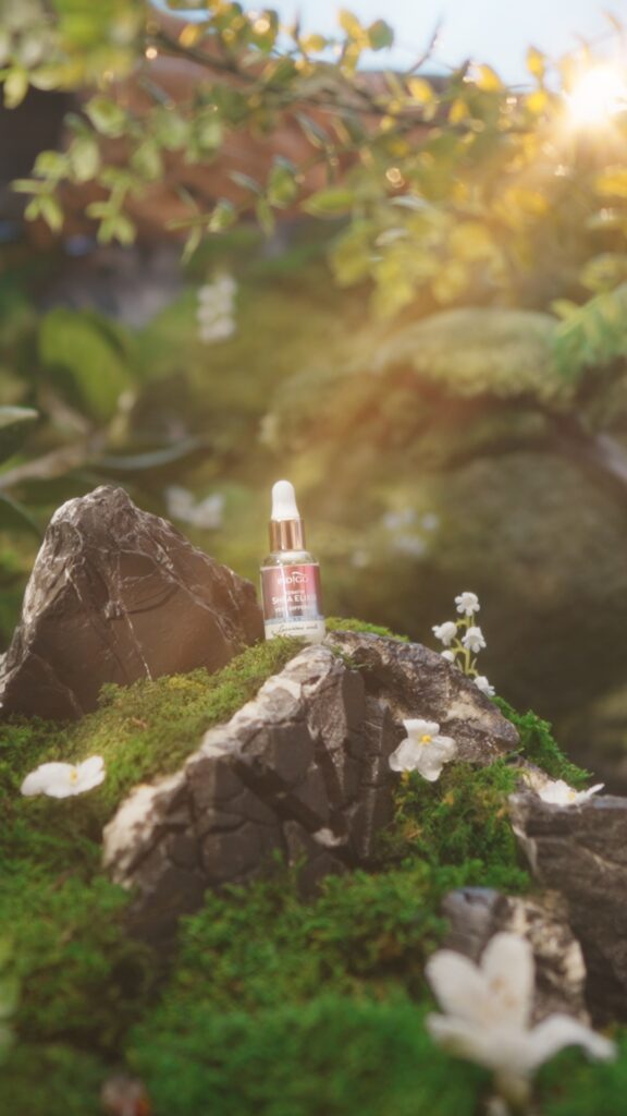 Butelka Shea Elixir, kosmetyk do paznokci Indigo Nails, umieszczona na skale, podkreślająca naturalne piękno otoczenia.