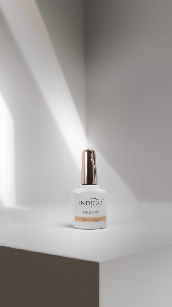 Butelka lakieru do paznokci Indigo Nails stoi na stole, otoczona naturalnym światłem, podkreślając jej elegancki design.
