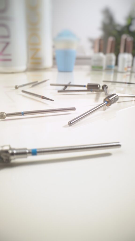 Stół z narzędziami do manicure, w tym frezami Indigo Nails, przygotowany do pracy.