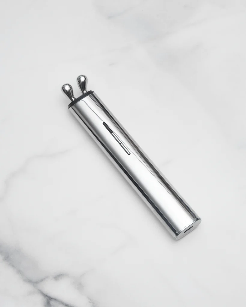 AURA RF masażer liftingujący na jasnym tle, widoczna cała obudowa i przyciski.